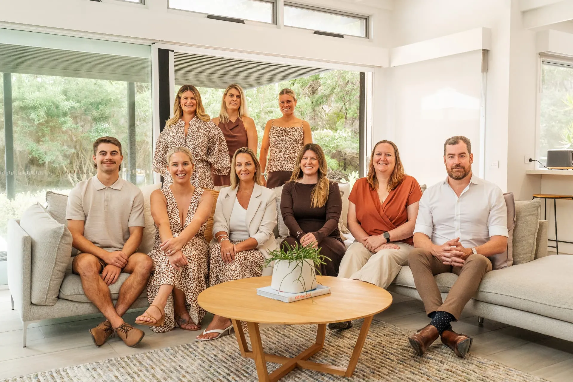 The Future Finance Group team gathered on a sofa around a timber coffee table in their office