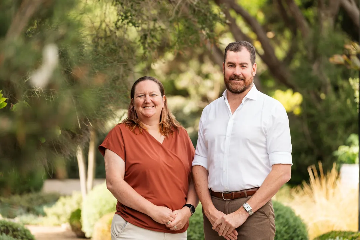 Two Future Finance Group team members smiling side by side in a garden